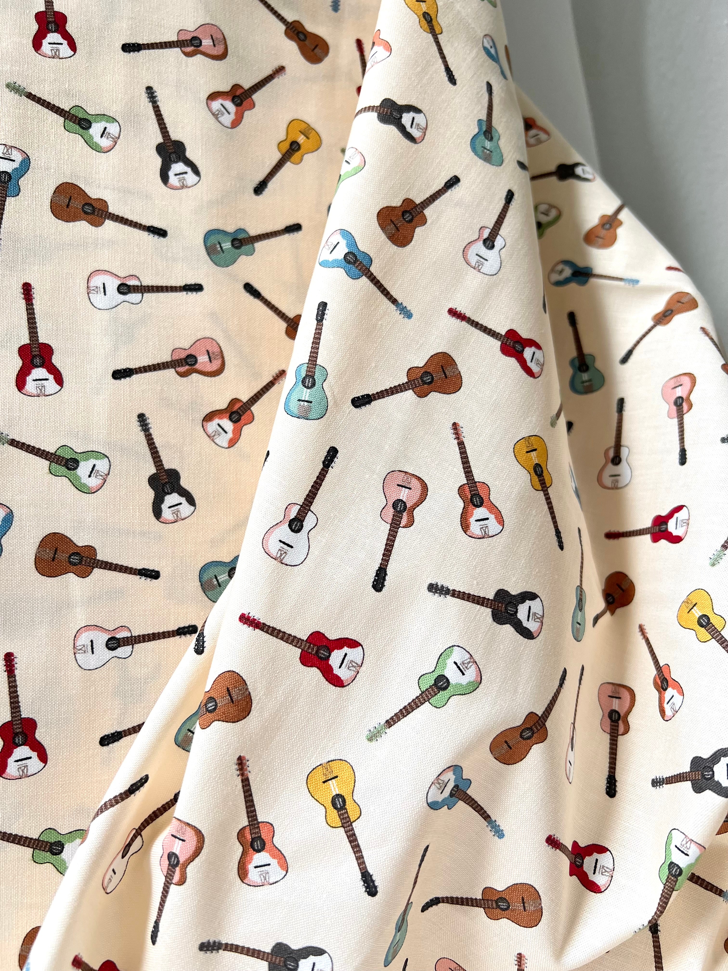 Tossed Guitars- 100% Cotton Fabric- On Cream- 44” Wide