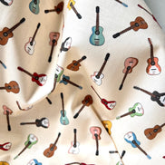 Tossed Guitars- 100% Cotton Fabric- On Cream- 44” Wide