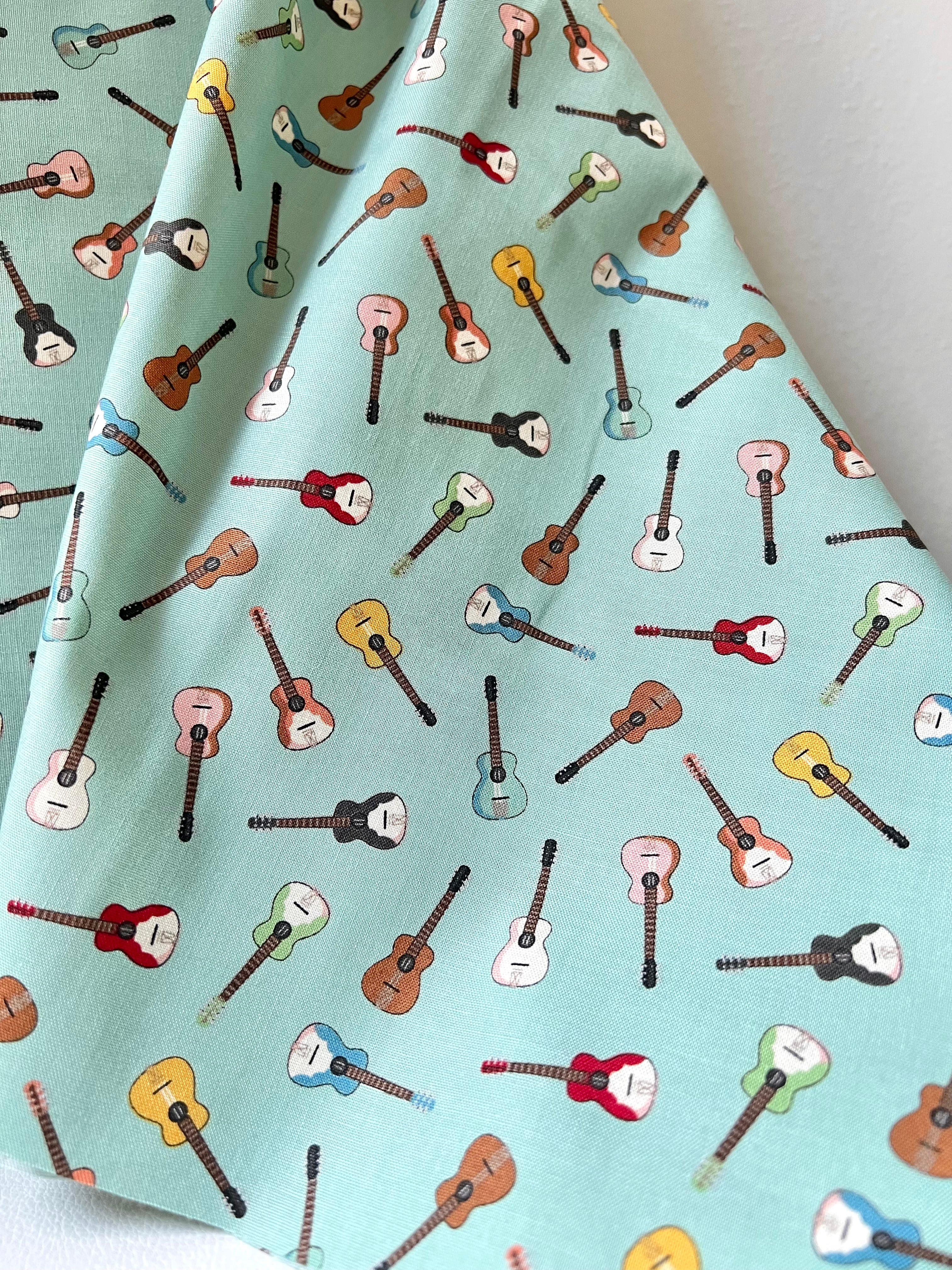 Tossed Guitars- 100% Cotton Fabric- On Light Teal/ Aqua- 44” Wide