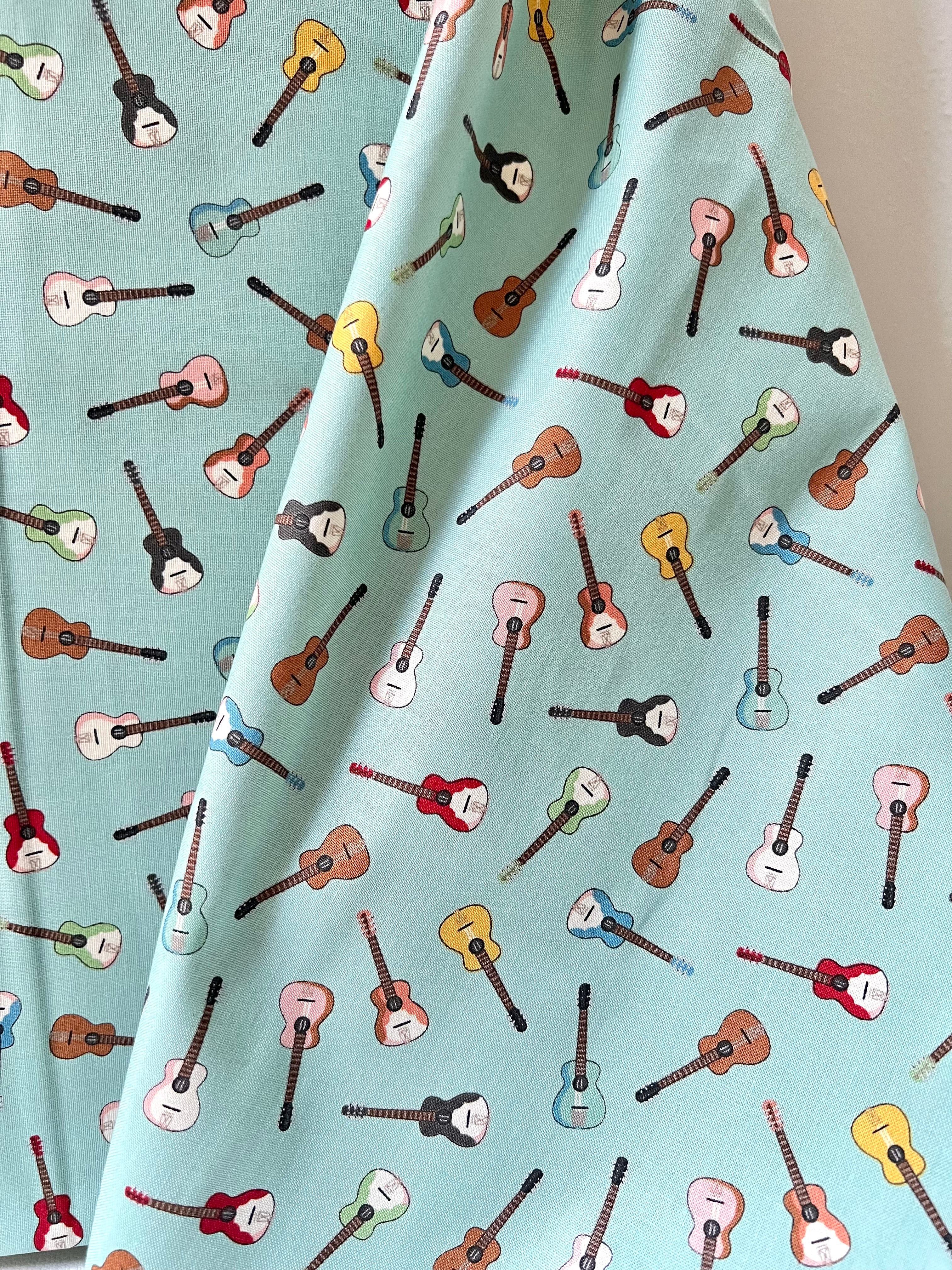 Tossed Guitars- 100% Cotton Fabric- On Light Teal/ Aqua- 44” Wide